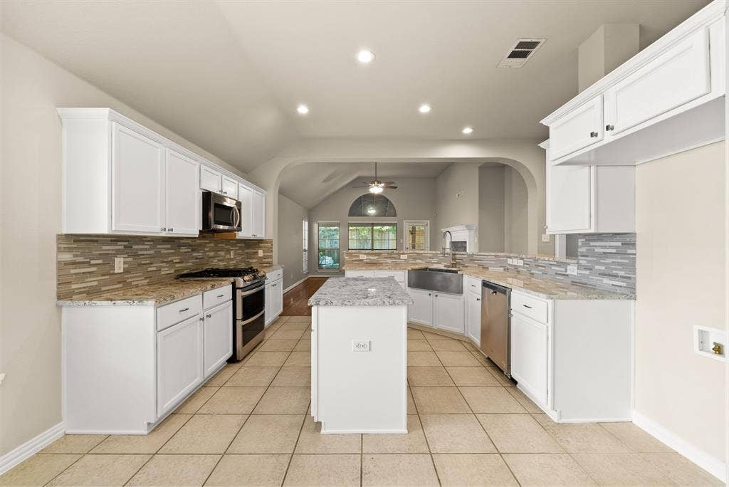 242 Cox Drive, Fate, TX 75087 Kitchen featuring white cabinetry, stainless steel appliances, granite countertops, and a tile backsplash