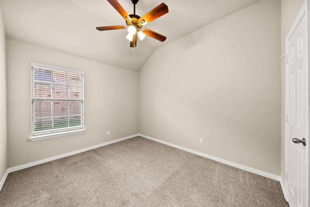 242 Cox Drive, Fate, TX 75087 Vaulted ceiling with an attached ceiling fan, neutral wall tones, and carpeted flooring