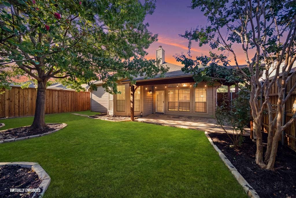 242 Cox Drive, Fate, TX 75087 Expansive backyard featuring a manicured lawn, established trees, and a wooden privacy fence