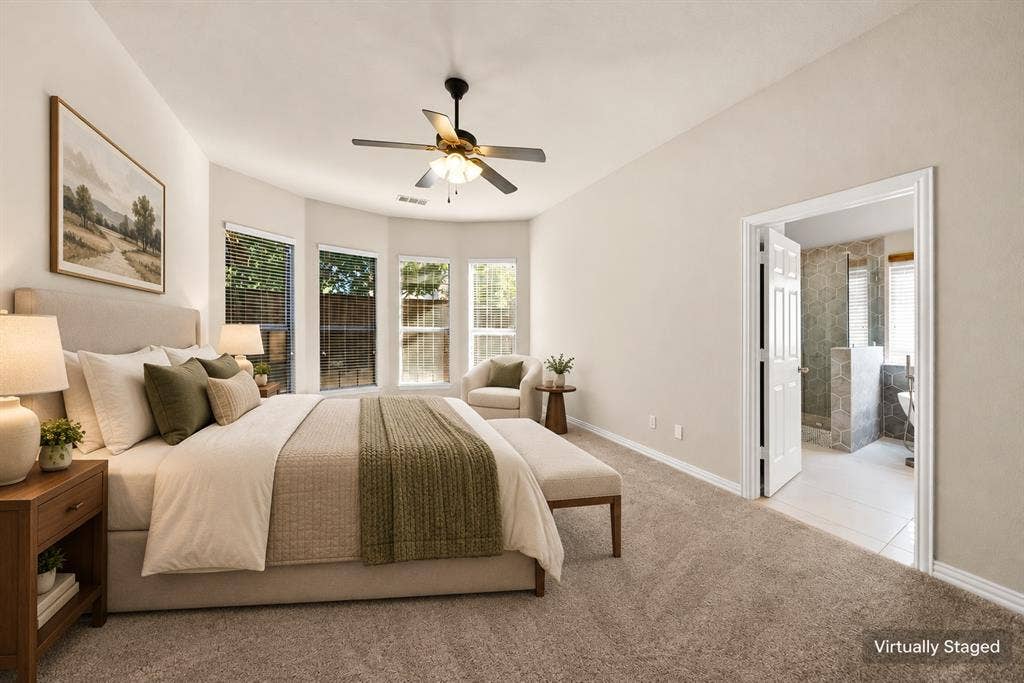 242 Cox Drive, Fate, TX 75087 Vaulted ceiling with a ceiling fan, bay windows with blinds, plush carpeting, and an adjoining bath with tiled flooring