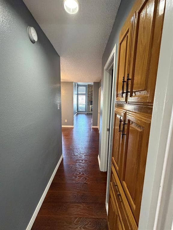 2200 W Park Boulevard, #1003, Plano, TX 75075 Hallway featuring wood-finish flooring, recessed ceiling lighting, and built-in wood cabinetry with dark hardware