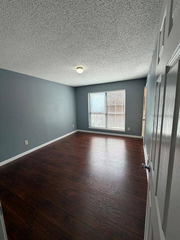 2200 W Park Boulevard, #1003, Plano, TX 75075 Interior room featuring wood-finish flooring, blue-toned walls, a textured ceiling, and a large window with fitted blinds