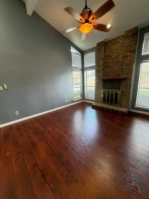 2200 W Park Boulevard, #1003, Plano, TX 75075 Vaulted ceiling featuring wood-finish flooring, floor-to-ceiling brick masonry fireplace, elevated mantel, and multi-pane windows