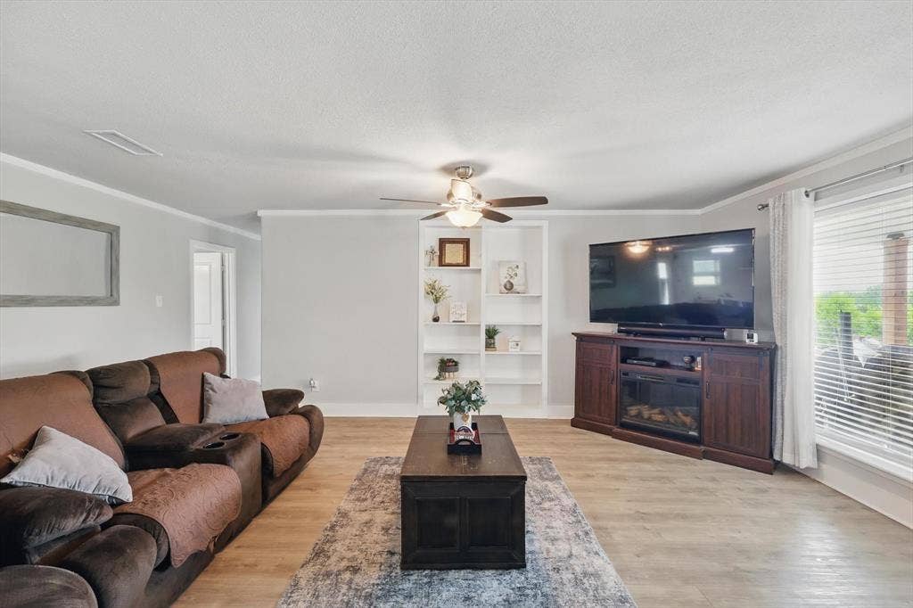5247 Fm 1569, Farmersville, TX 75442 Recessed built-in shelving, ceiling fan with integrated lighting, wood-finish flooring, and crown molding