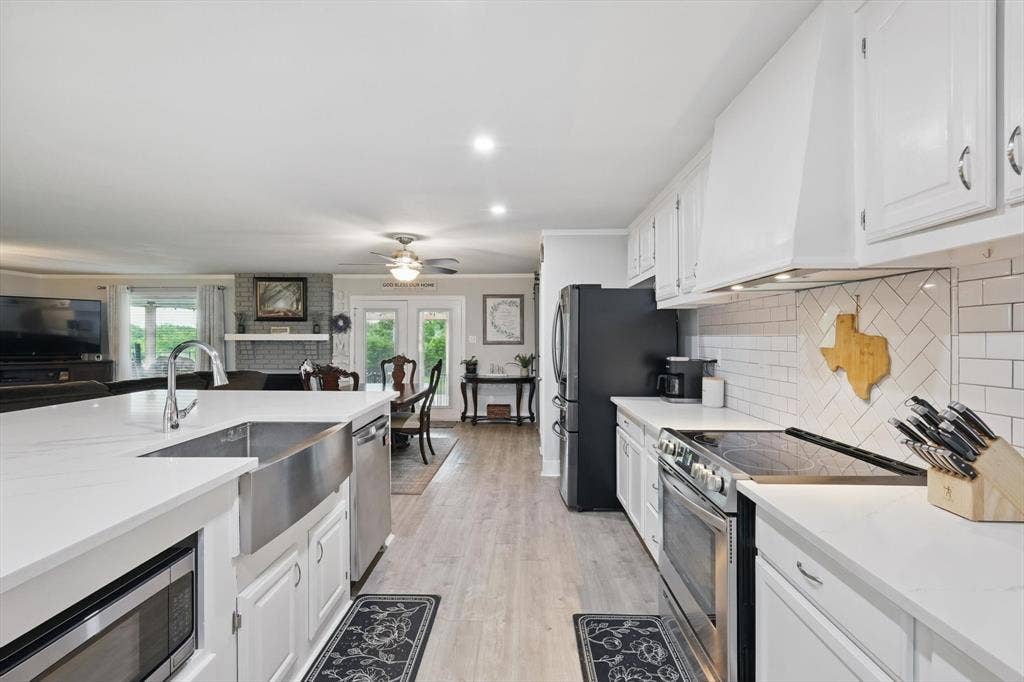 5247 Fm 1569, Farmersville, TX 75442 Kitchen featuring white cabinetry, light countertops, wood-finish flooring, and subway tile backsplash