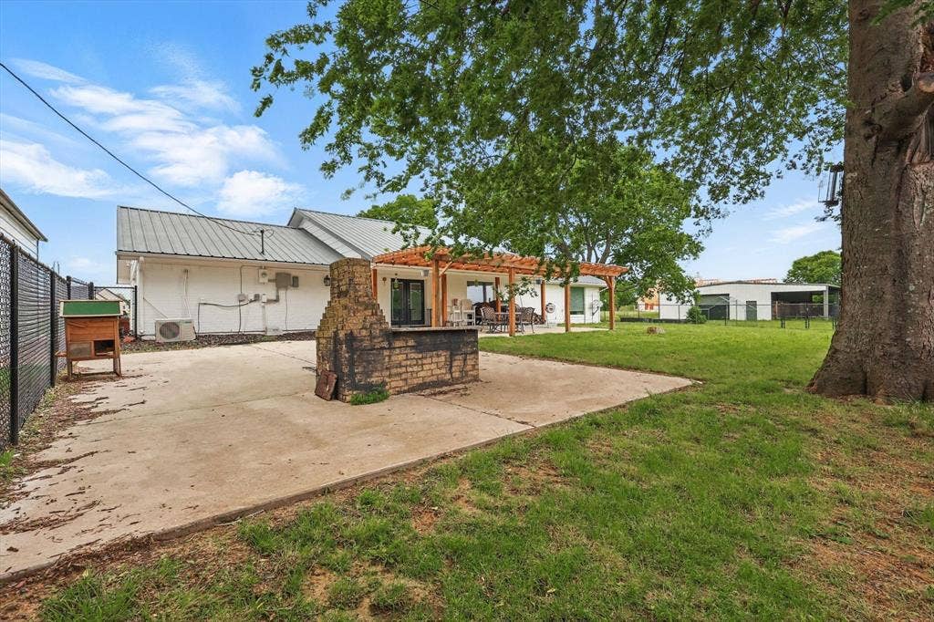 5247 Fm 1569, Farmersville, TX 75442 Concrete patio with a built-in brick grilling station, a pergola, and a grassy yard area