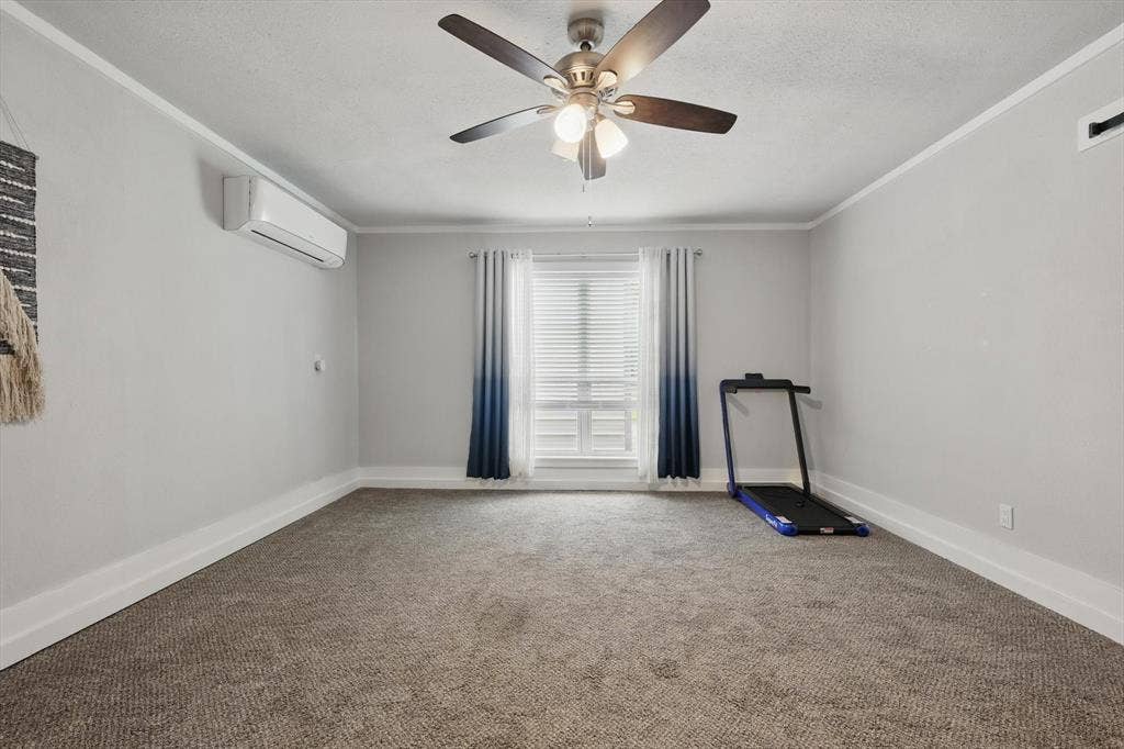 5247 Fm 1569, Farmersville, TX 75442 Neutral wall paint, ceiling fan with integrated lighting, window with blinds, wall-mounted air conditioning unit, and carpet flooring