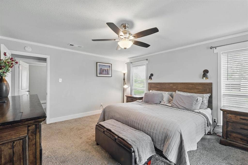 5247 Fm 1569, Farmersville, TX 75442 Neutral wall paint, crown molding, ceiling fan with integrated lighting, two windows with blinds, and carpeted flooring