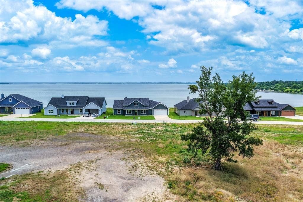 200 Caro Drive, West Tawakoni, TX 75454 Expansive residential lot featuring waterfront placement with clear shoreline frontage and mature tree growth