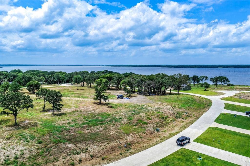 200 Caro Drive, West Tawakoni, TX 75454 Expansive waterfront lot featuring mature trees, paved access roads, and unobstructed water frontage