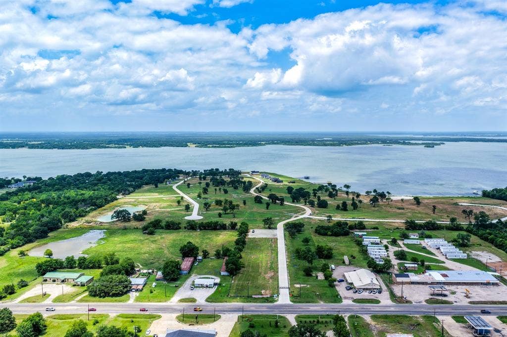 200 Caro Drive, West Tawakoni, TX 75454 Aerial perspective of expansive waterfront acreage featuring cleared pasture land, multiple interior ponds, and extensive shoreline frontage