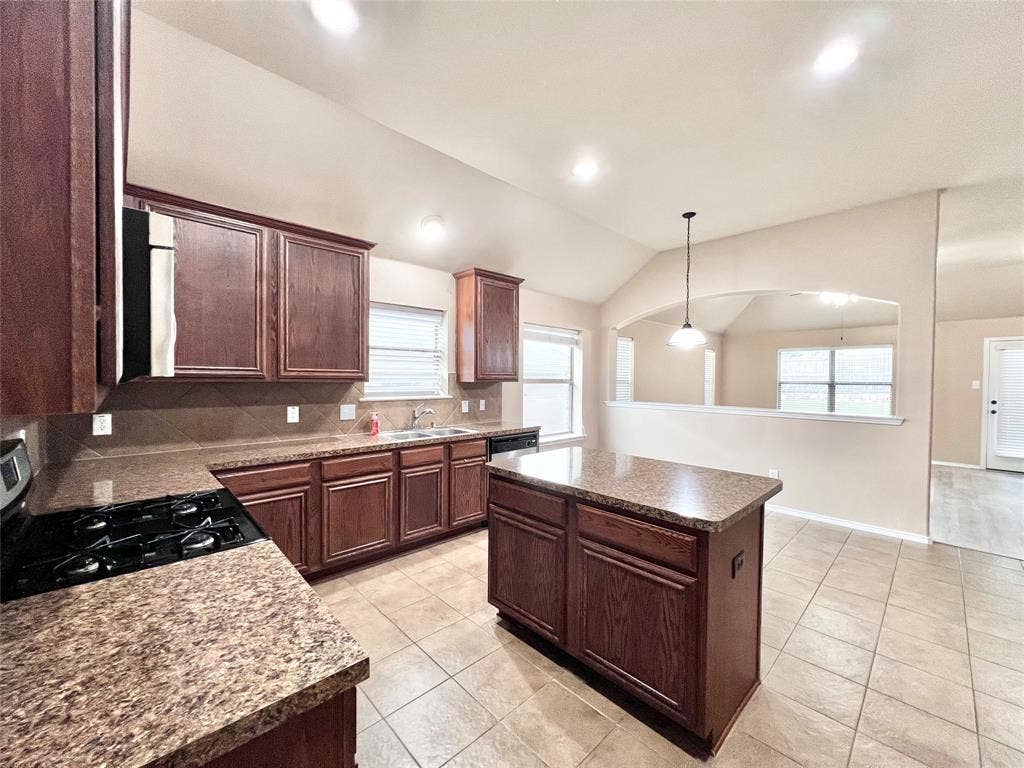 5204 Bear Valley Drive, McKinney, TX 75071 Kitchen featuring a central island, recessed lighting, tile flooring, wood cabinetry, and solid surface countertops