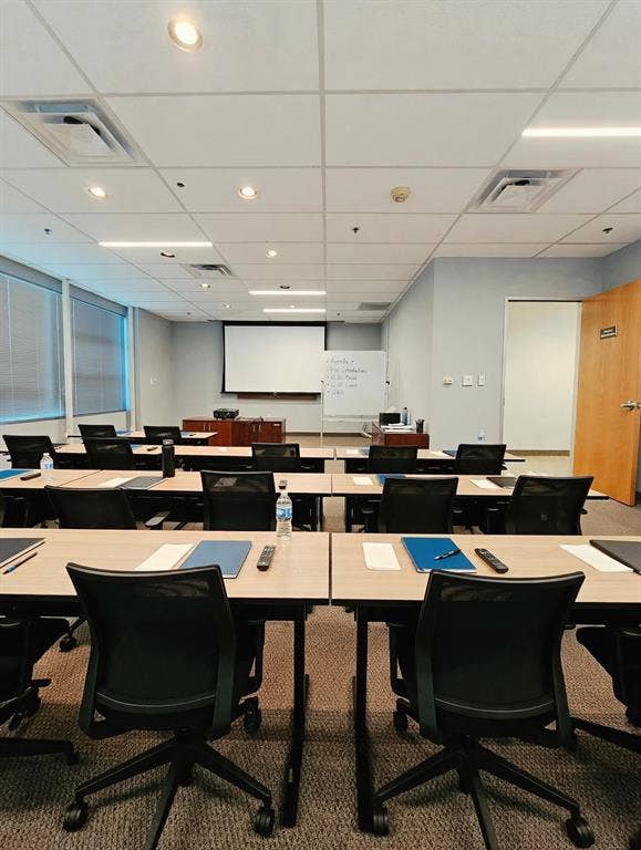 1675 Republic Parkway, #201B, Mesquite, TX 75150 Modern training or conference room featuring multiple workstations with ergonomic black task chairs, light wood-finish tables, and abundant natural light from floor-to-ceiling windows