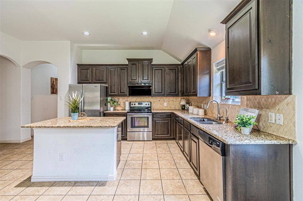 Kitchen with wood-finish cabinetry, granite countertops, and stainless steel appliances