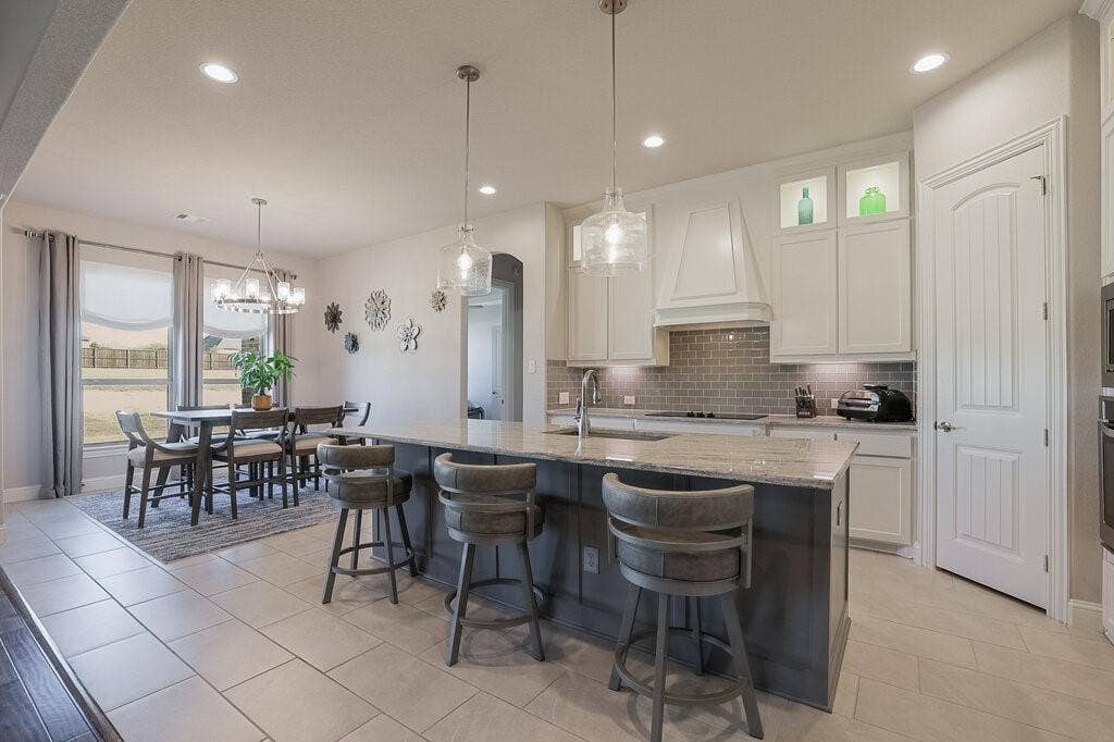 Kitchen featuring a central island, recessed lighting, pendant lighting, light-toned cabinetry, and a subway tile backsplash