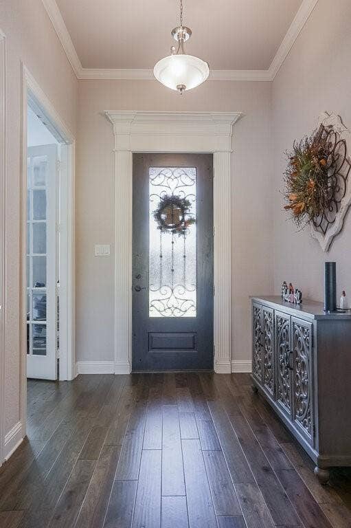 Entryway featuring wood-finish flooring, a decorative front door with ironwork, and an overhead semi-flush mount light fixture