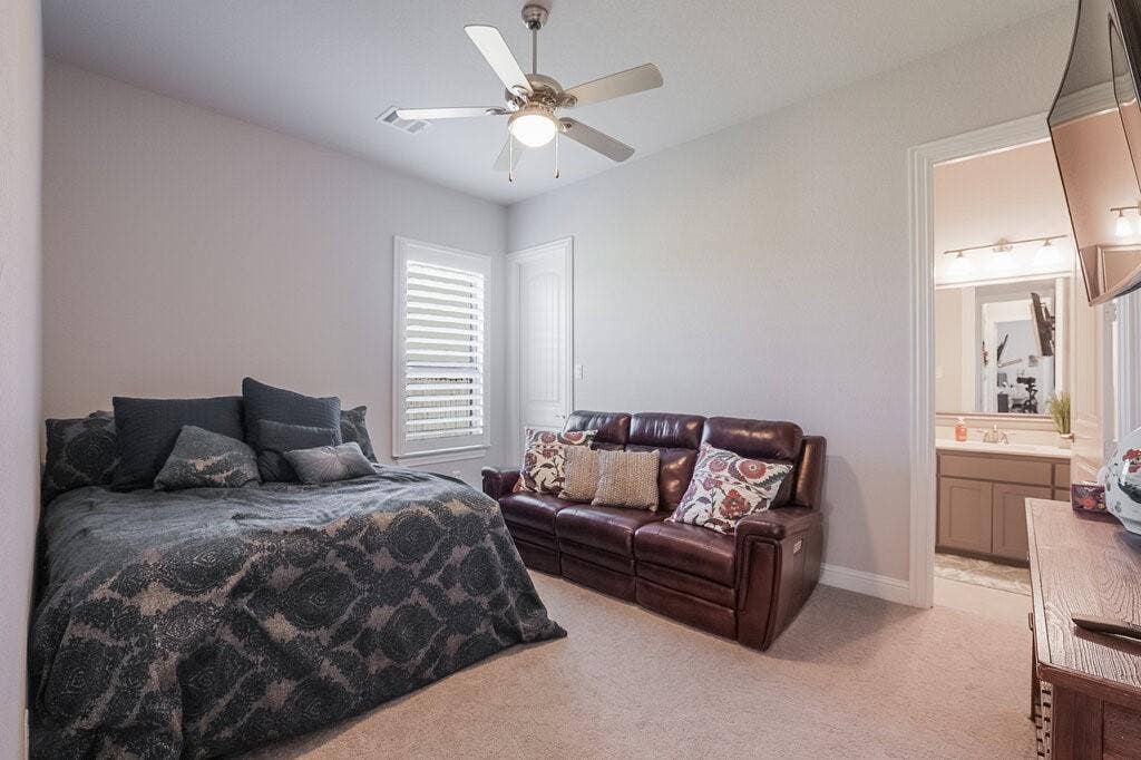 Recessed lighting, ceiling fan, window with white plantation shutters, and light-colored carpeting