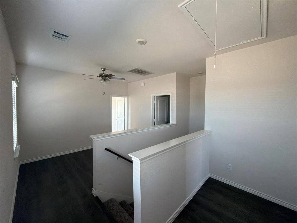 Wood-finish flooring, ceiling fan with integrated lighting, and neutral wall tones