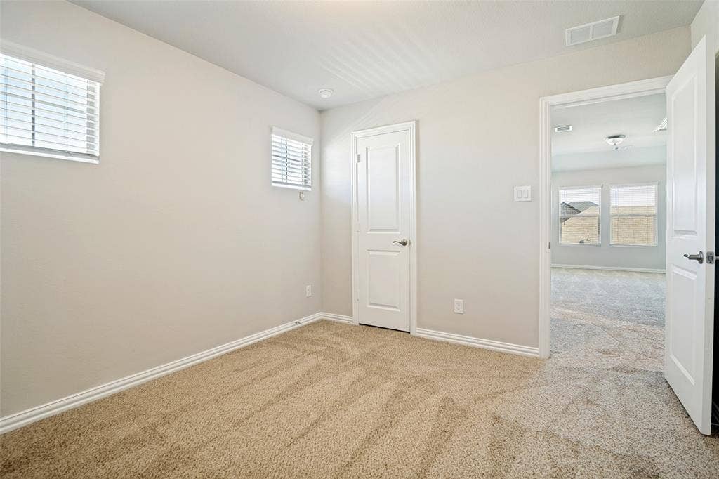 Neutral wall finishes, recessed lighting, two windows with blinds, and carpeted flooring