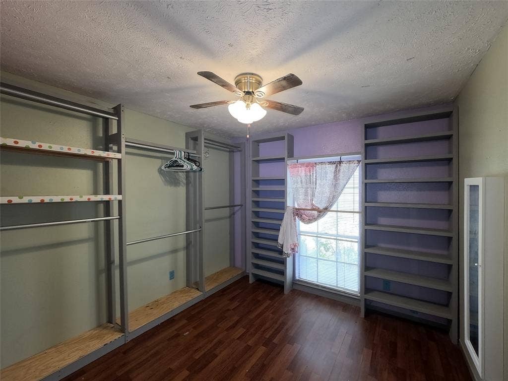21 W Townhouse Lane, #33, Grand Prairie, TX 75052 Wood-finish flooring, built-in shelving, built-in clothing rods, and ceiling fan with integrated lighting