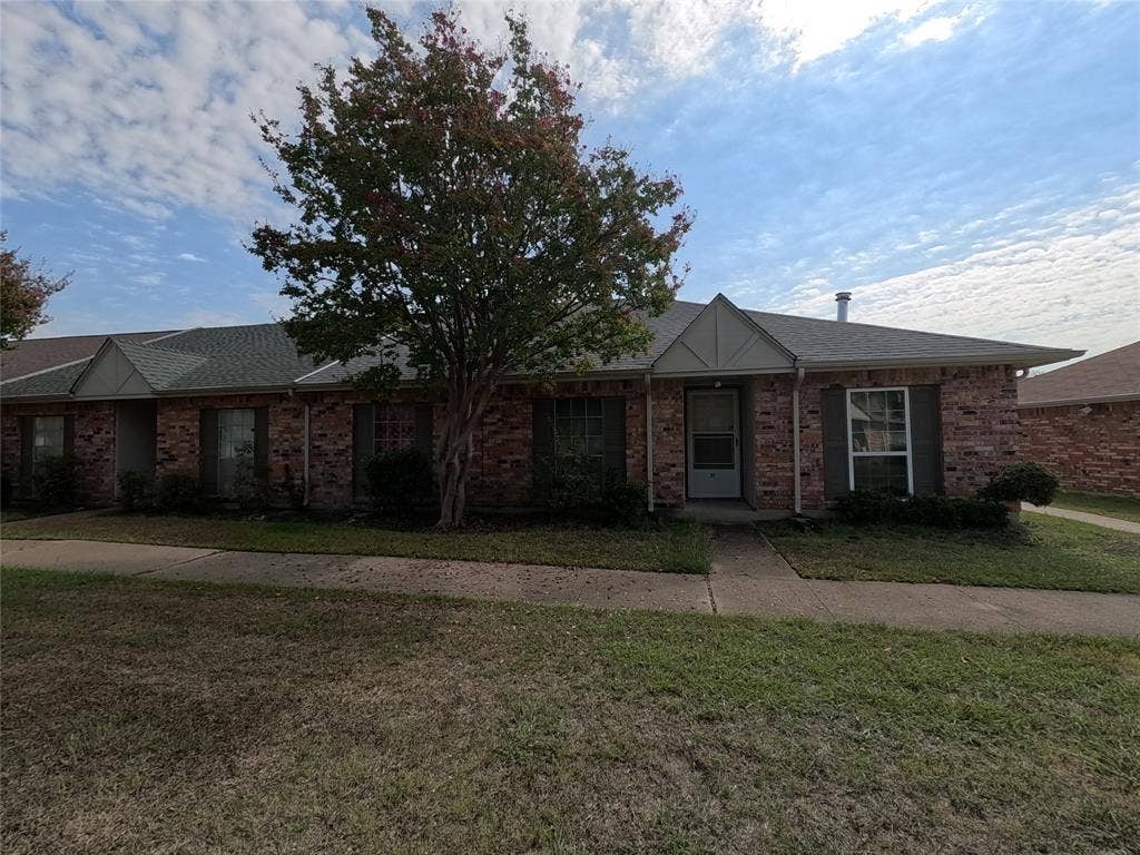 21 W Townhouse Lane, #33, Grand Prairie, TX 75052 Brick exterior with shuttered windows, a gabled entry, and a paved walkway