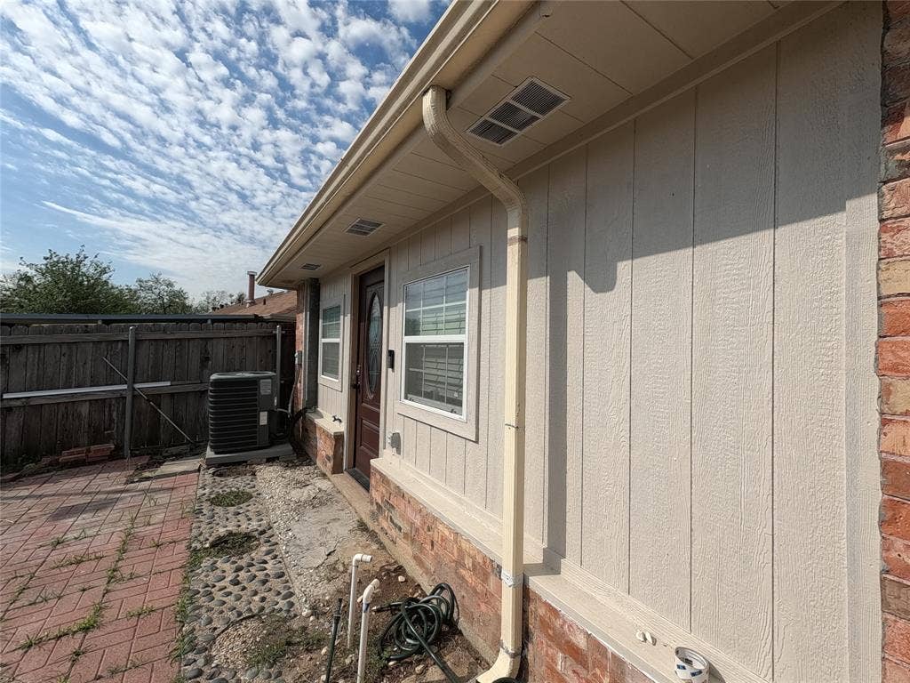 21 W Townhouse Lane, #33, Grand Prairie, TX 75052 Exterior siding with brick detailing, white window frames, and a dark entry door