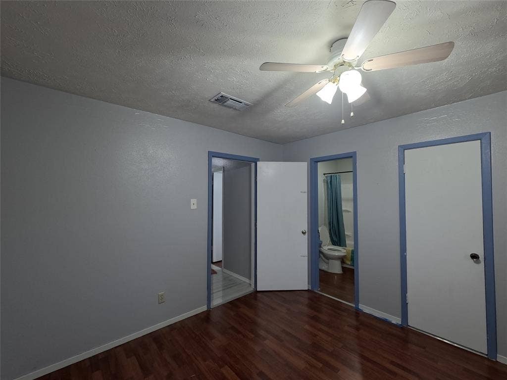 21 W Townhouse Lane, #33, Grand Prairie, TX 75052 Wood-finish flooring with light gray walls, white doors, and a ceiling fan with light fixture