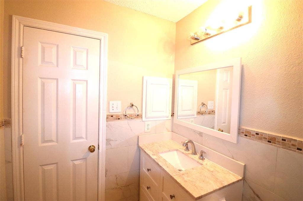 2222 Edinburgh Way, Garland, TX 75040 Vanity with light-colored countertop, undermount sink, and brushed nickel faucet