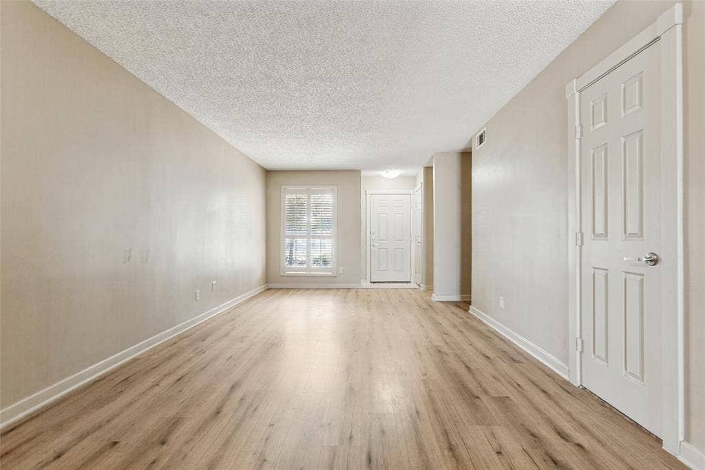 2111 E Belt Line Road, #158B, Richardson, TX 75081 Wood-finish flooring, neutral wall tones, window with blinds, white trim, and a paneled interior door