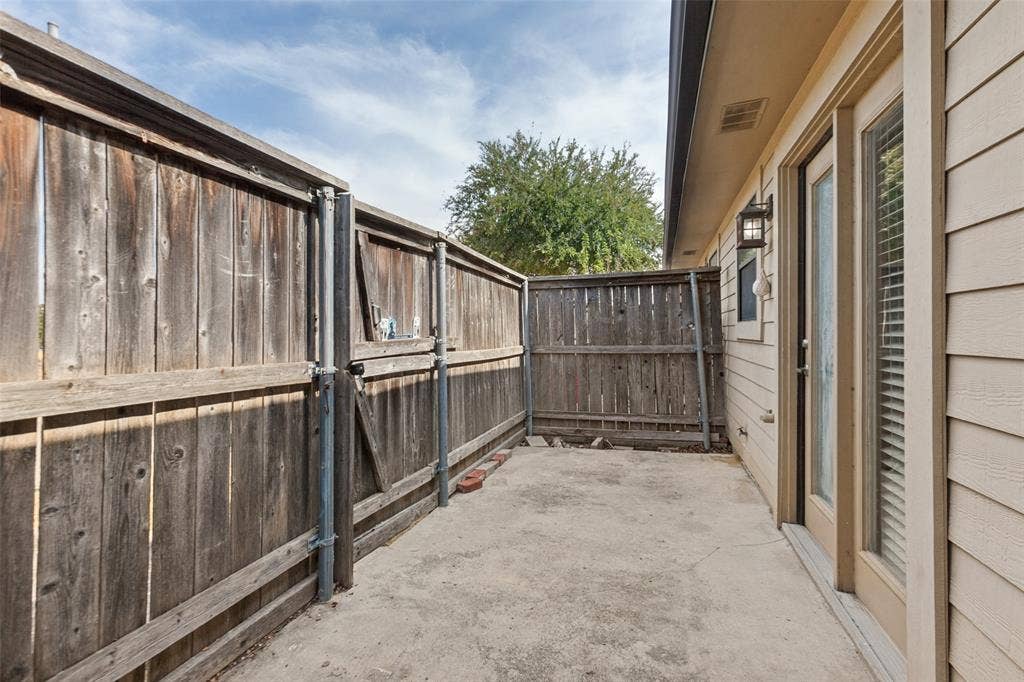 2111 E Belt Line Road, #158B, Richardson, TX 75081 Private patio with concrete flooring, wood privacy fencing, and exterior wall lighting