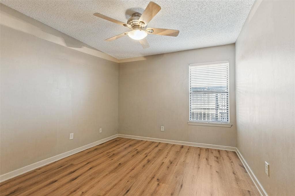 2111 E Belt Line Road, #158B, Richardson, TX 75081 Wood-finish flooring, ceiling fan with integrated lighting, window with blinds, and tray ceiling detailing
