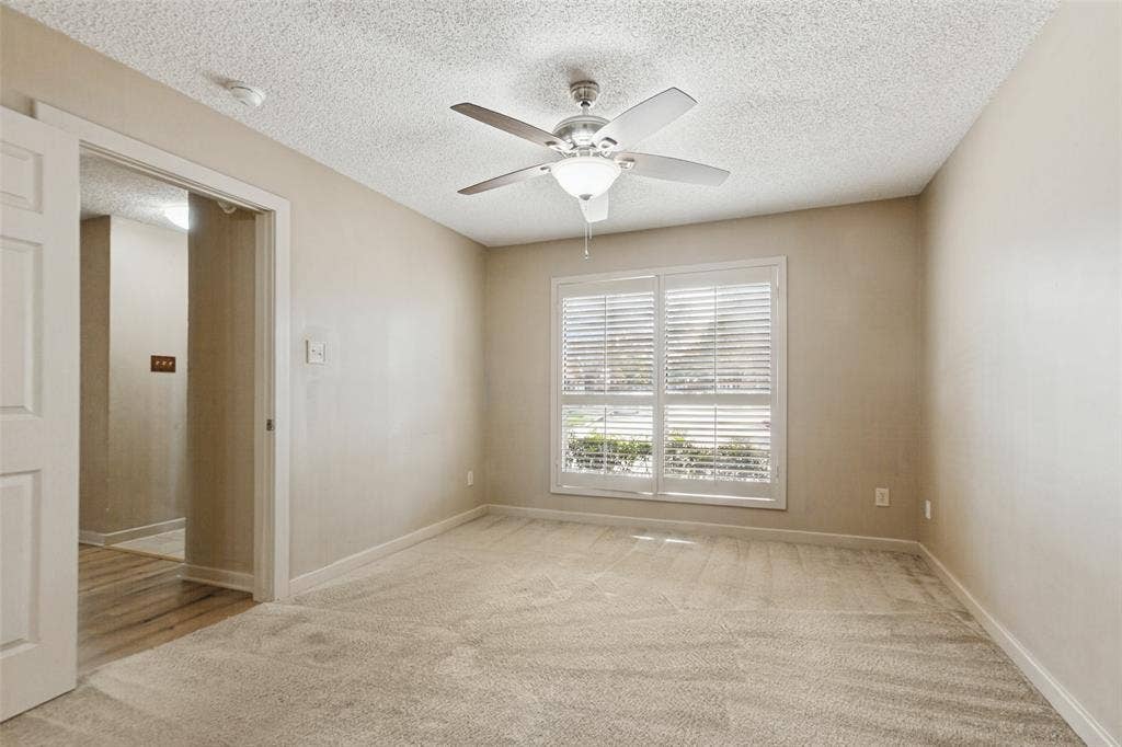2111 E Belt Line Road, #158B, Richardson, TX 75081 Neutral-toned walls with textured ceiling, carpeted flooring, and a ceiling fan with integrated lighting