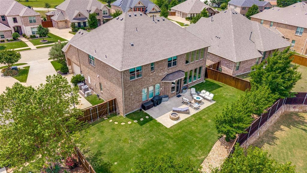 131 Darian Drive, Prosper, TX 75078 Brick exterior home with a gabled roof and a spacious backyard