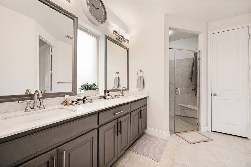 131 Darian Drive, Prosper, TX 75078 Double vanity with white countertops, undermount sinks, and dark wood-finish cabinetry