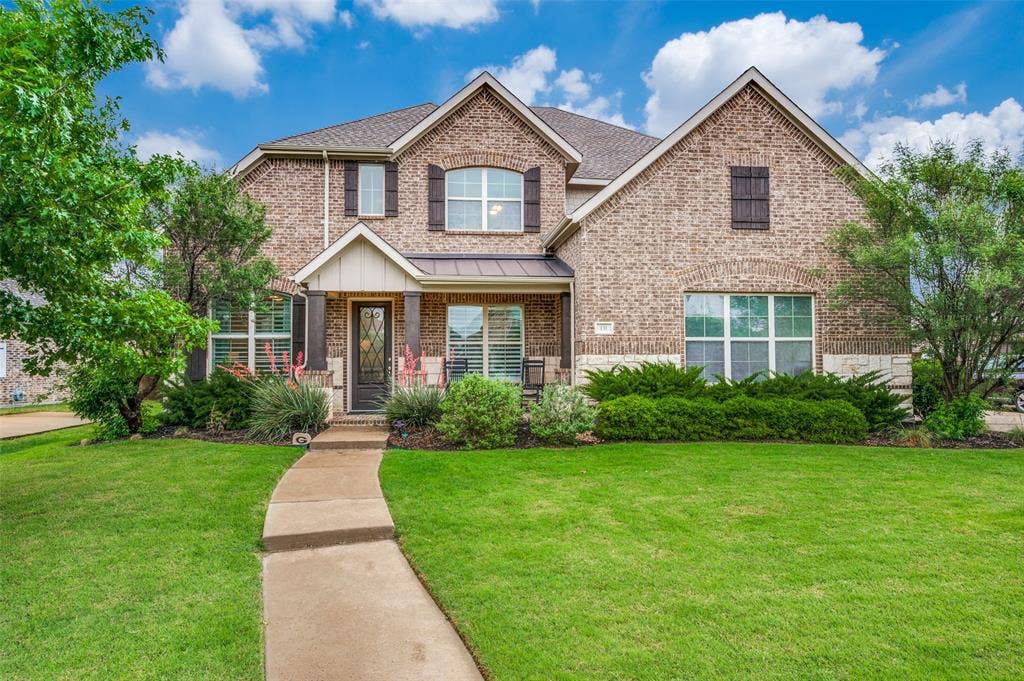 131 Darian Drive, Prosper, TX 75078 Two-story brick exterior with stone accents, covered front porch, and mature landscaping