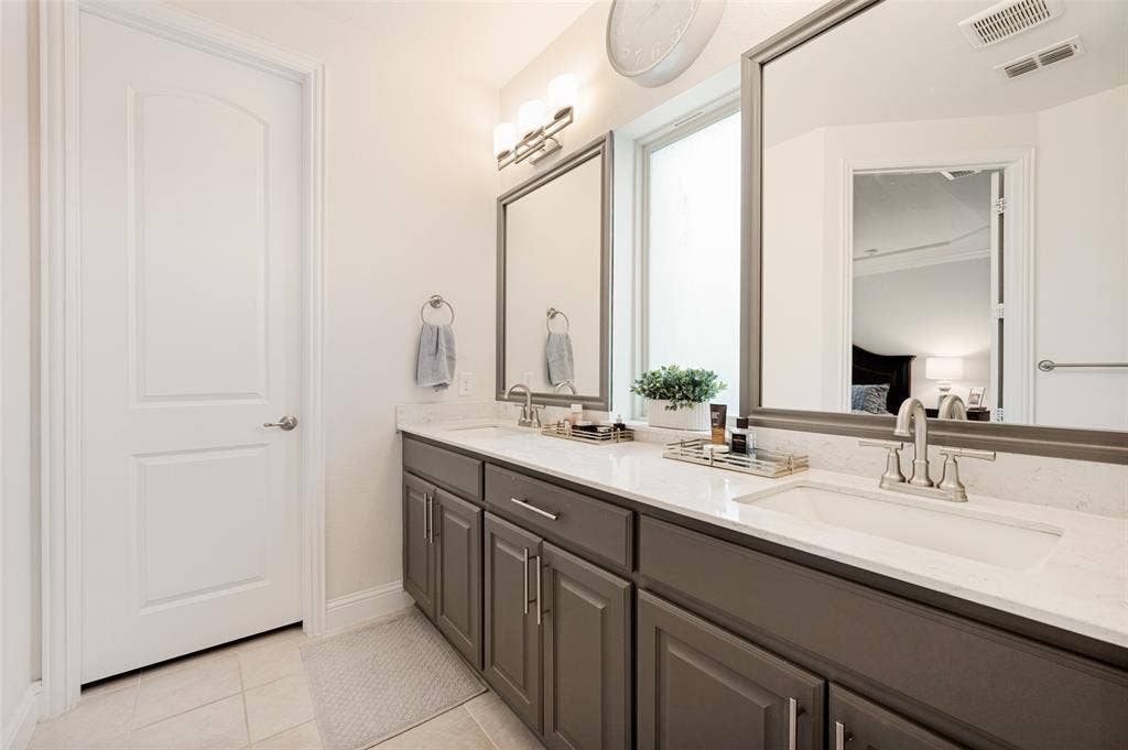 131 Darian Drive, Prosper, TX 75078 Dual vanity with gray cabinetry, white countertops, and integrated rectangular sinks