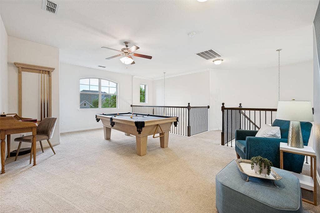 131 Darian Drive, Prosper, TX 75078 Expansive carpeted loft space featuring an arched window, ceiling fan with light, and open railings