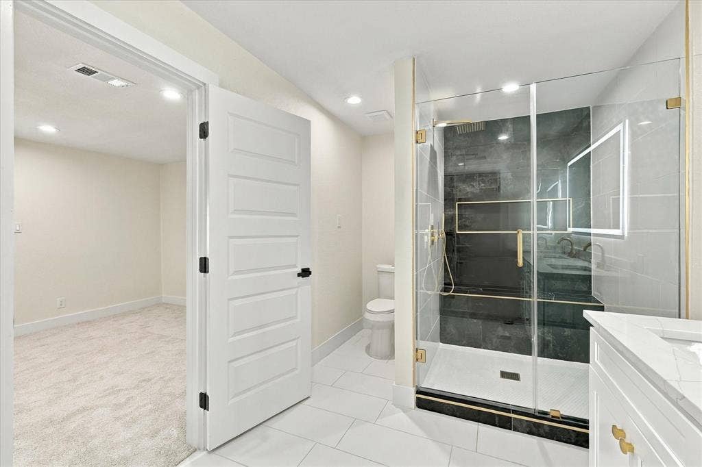 Walk-in closet featuring built-in shelving, two levels of hanging rods, and light-toned carpeting