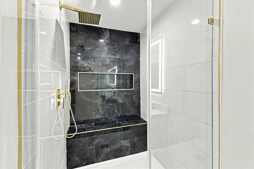 White dual vanity with integrated sinks, gold-finish faucets, white shaker-style cabinetry, and light wood-finish flooring
