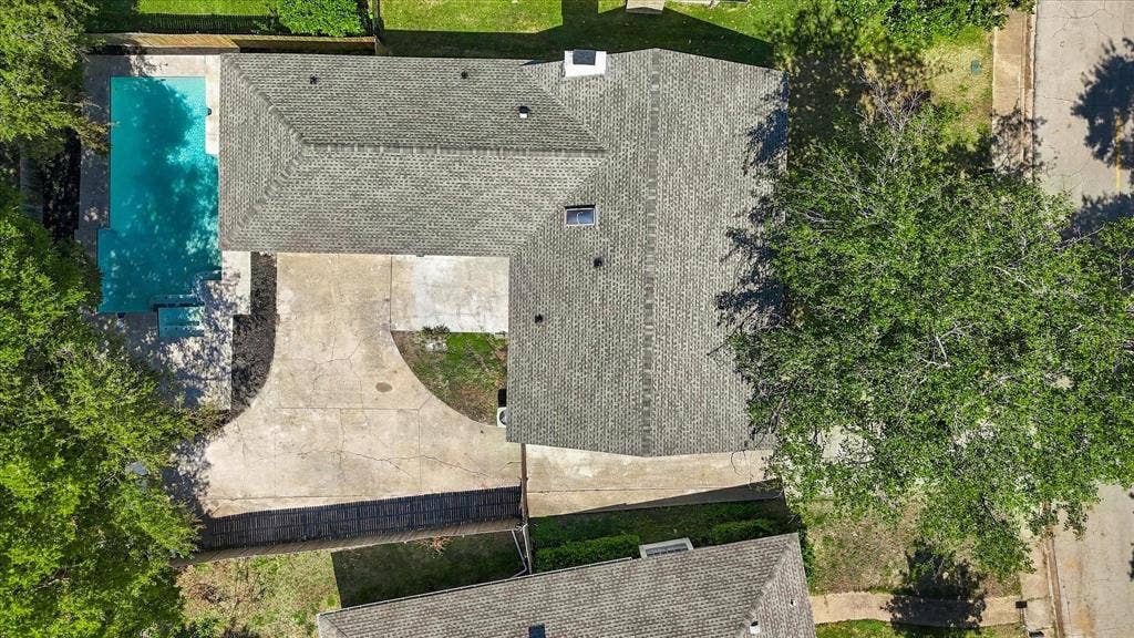 Expansive backyard with a rectangular swimming pool, concrete patio, and a wood privacy fence