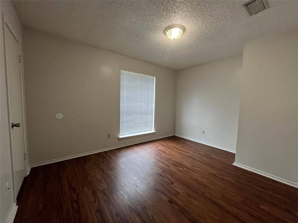 724 Ballard Street, Cedar Hill, TX 75104 Empty room featuring dark hardwood / wood-style flooring and a textured ceiling