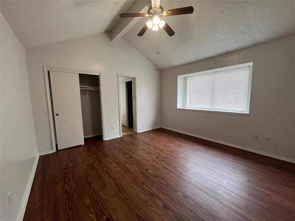 724 Ballard Street, Cedar Hill, TX 75104 Unfurnished bedroom with vaulted ceiling with beams, a textured ceiling, dark hardwood / wood-style flooring, ceiling fan, and a closet