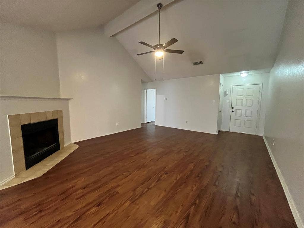 724 Ballard Street, Cedar Hill, TX 75104 Unfurnished living room with vaulted ceiling with beams, ceiling fan, a fireplace, and hardwood / wood-style flooring