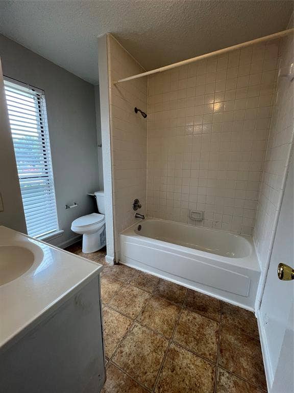 724 Ballard Street, Cedar Hill, TX 75104 Full bathroom featuring vanity, tiled shower / bath, toilet, a textured ceiling, and tile patterned flooring