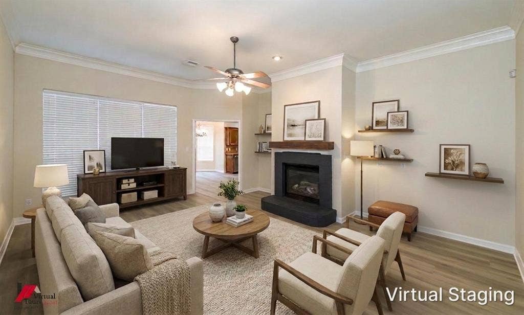 Virtually staged. Living area featuring wood-finish flooring, a fireplace with a black surround, a wood mantel, crown molding, and recessed lighting