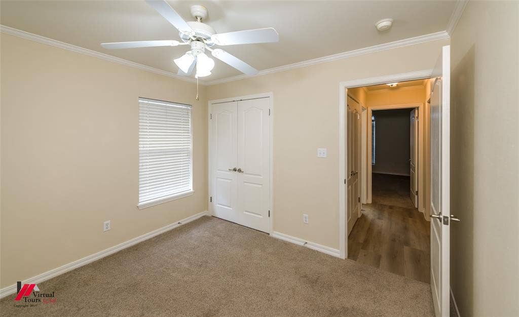 Room featuring neutral-toned carpeting, a ceiling fan with integrated lighting, window blinds, and dual-panel closet doors