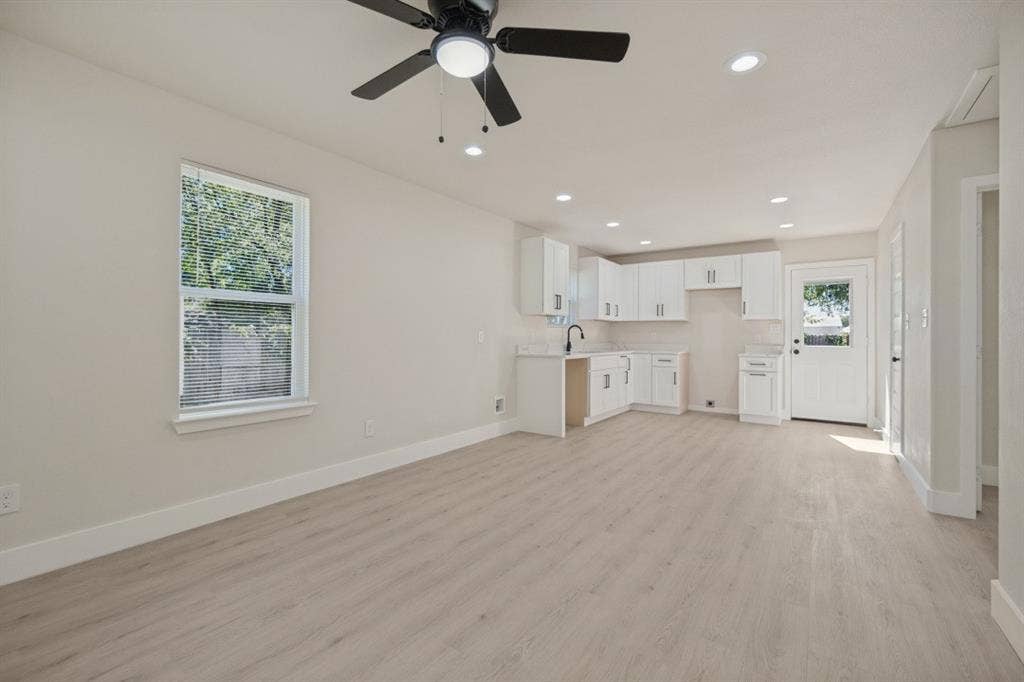 Open-concept living space featuring wood-finish flooring, recessed lighting, and a ceiling fan