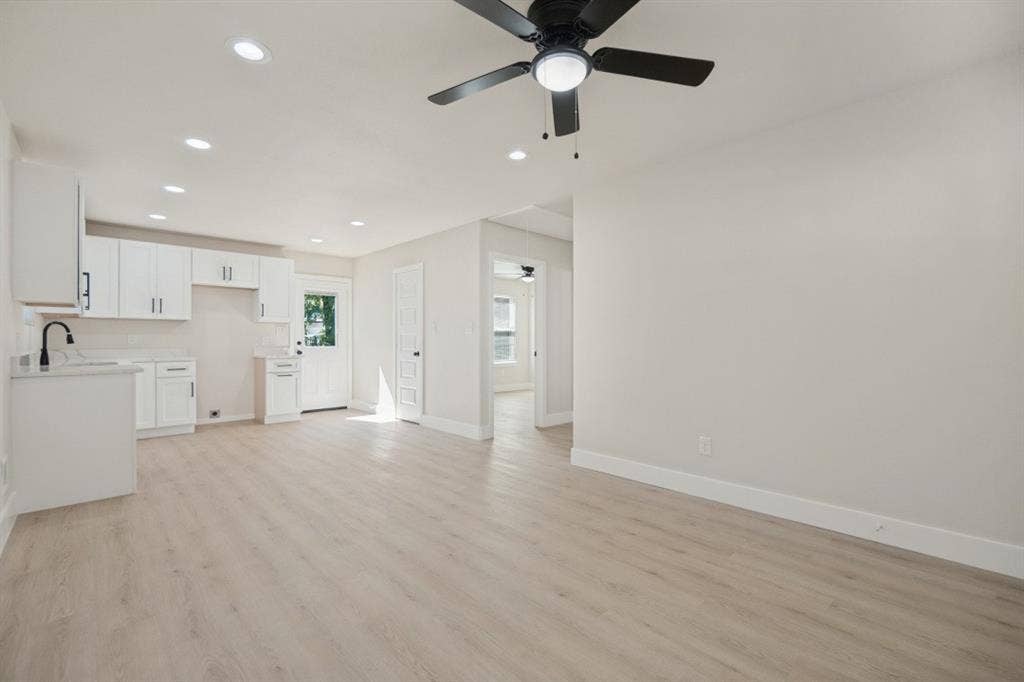 Recessed lighting, wood-finish flooring, and a ceiling fan with integrated lighting
