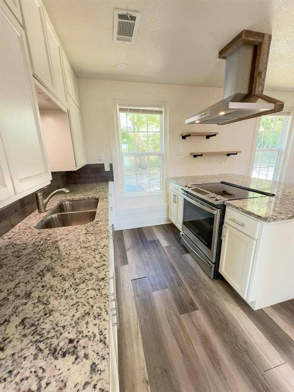 150 Fm 1996, Oglesby, TX 76561 Kitchen featuring granite countertops, stainless steel appliances, white cabinetry, and a wood-wrapped range hood