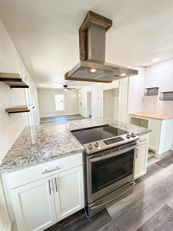 150 Fm 1996, Oglesby, TX 76561 Kitchen island featuring a built-in stainless steel range, mottled countertop, and white cabinetry with silver-tone hardware